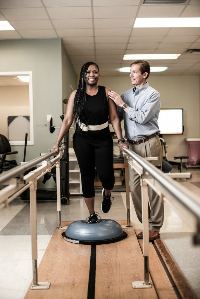 Woman in Rehab walking with bars