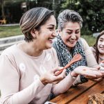 latin grandmother and granddaughter, daughter cooking  food at home