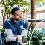 At the school garden, the mid adult male community outreach volunteer teaches children gardening.