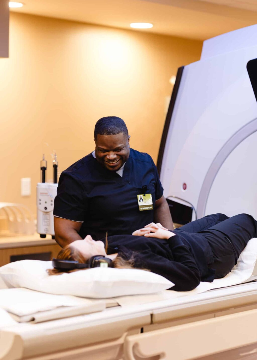 Inpatient CT Tech Lead preparing patient for scan