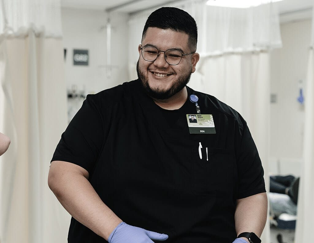 A nurse smiling and interacting with others in a hospital care environment.