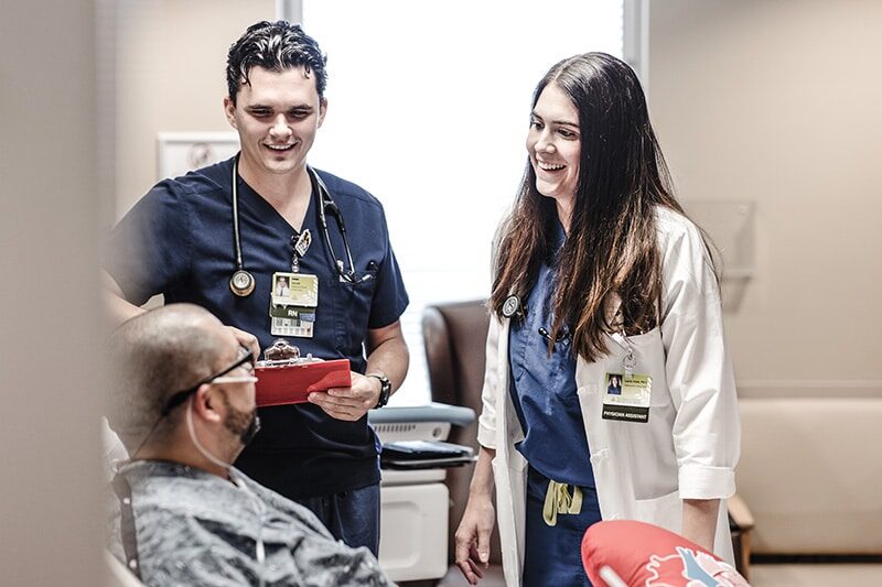 Healthcare professionals speaking with a patient in a hospital room