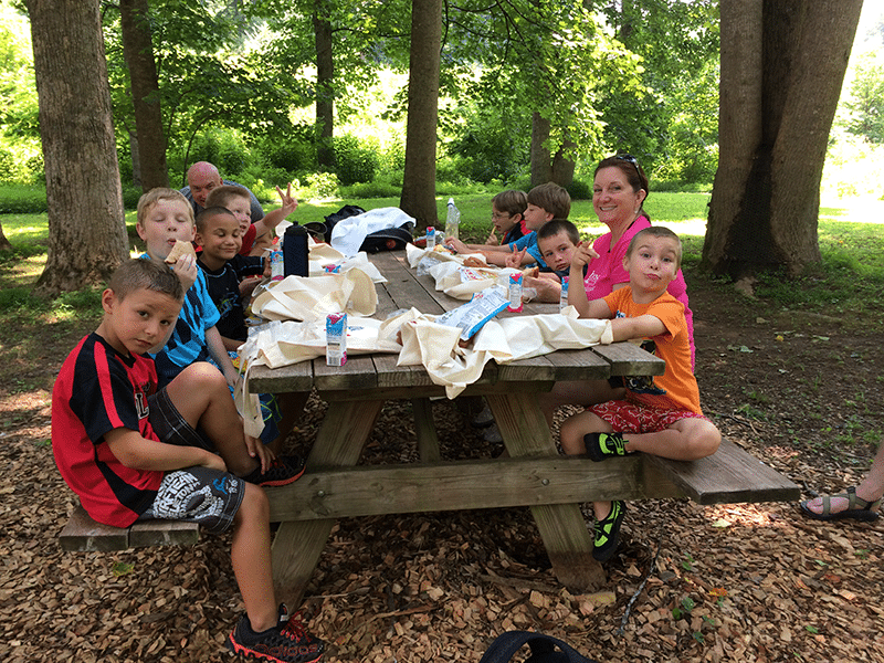 family around a picnic table in the woods