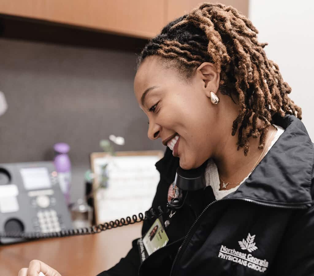 Healthcare professional answering the phone, in an office setting.