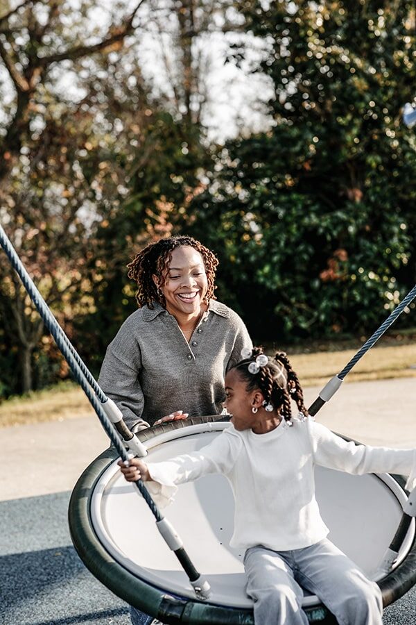 Healthcare employee watching daughter swing